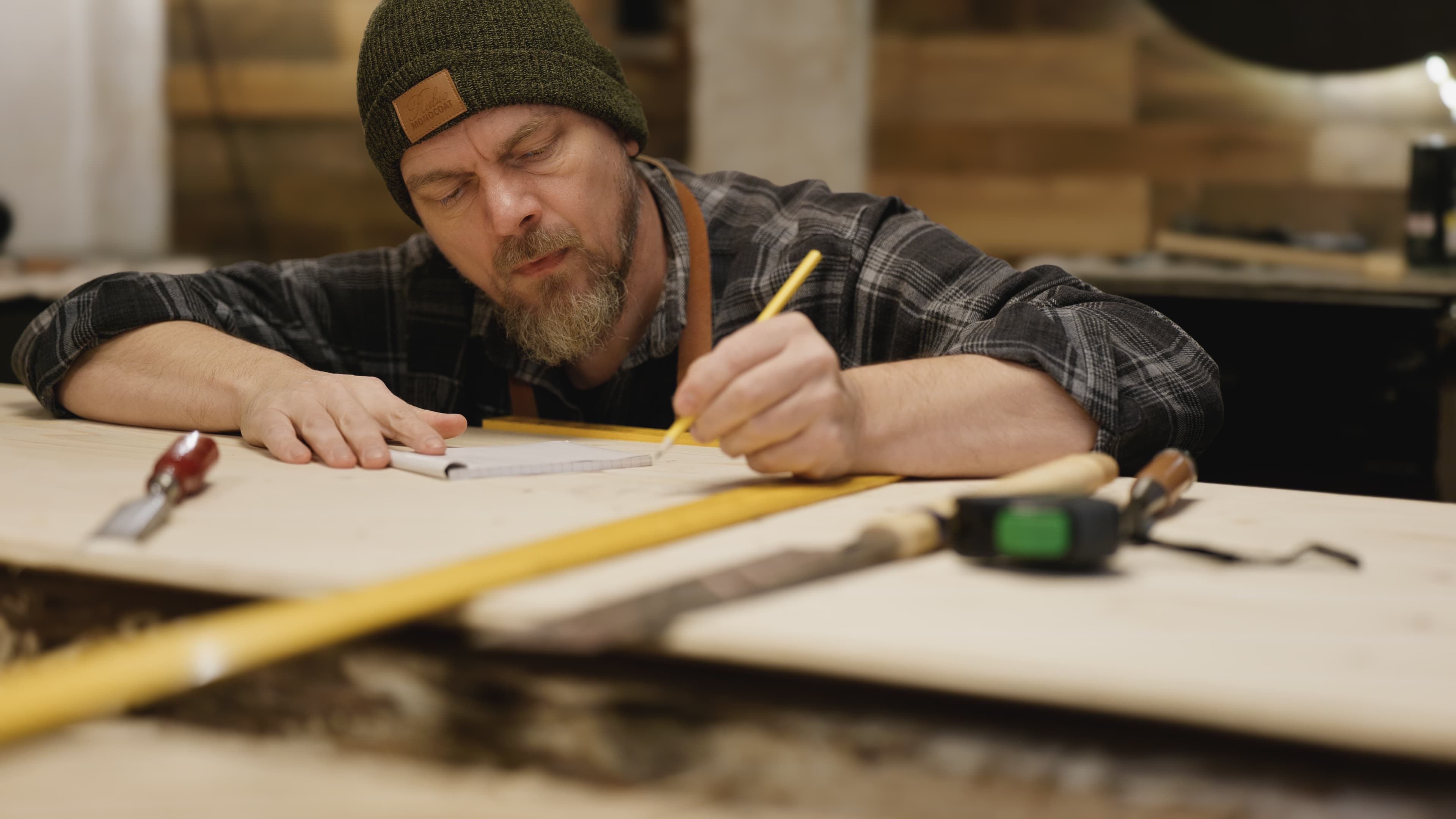 Jesper measuring and marking wood at the workbench